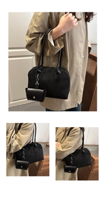Detail of black suede Boston bag with leather handles and matching small coin purse