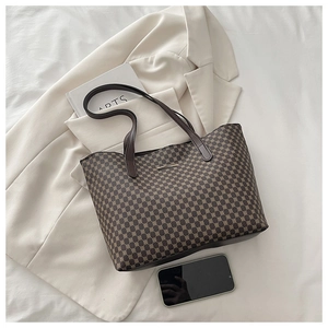 Detailed macro of vintage brown tote bag texture with gold logo and geometric patterns
