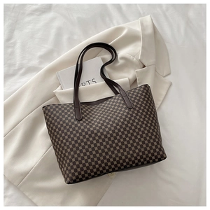 Detail of vintage tote bag with geometric monogram pattern on a premium fabric surface