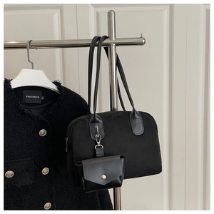 Close-up of black velvet tote bag with a small leather pouch and silver metal lobster clasp