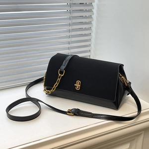 Black leather crossbody bag with gold chain strap and metal lock closure on window background