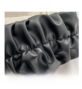 Detailed close-up of premium black pleated leather texture on a cloud crossbody bag