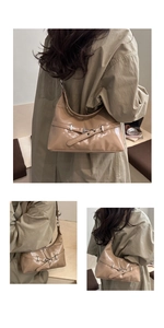 Detail of khaki patent leather shoulder bag featuring horizontal decorative buckle and eyelets