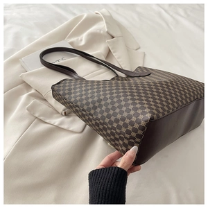 Detail of vintage brown patterned tote bag on white jacket, spacious commuter style