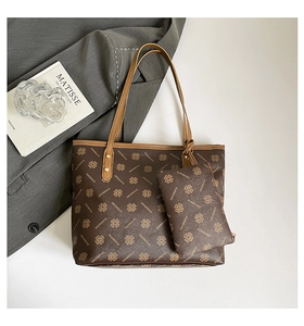 Detail of printed brown tote bag set with matching small pouch on a grey background