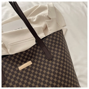 Detail of vintage geometric plaid pattern on brown tote bag with gold metal buckle