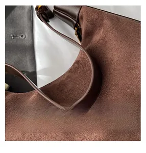 Detail showing high-quality dark coffee suede material and smooth leather stitching