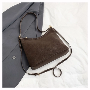 Close-up of vintage brown suede tote with dual straps and elegant golden hardware accents