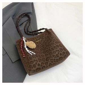 Detail of leopard print tote bag featuring Creative Cat text and woven handle