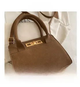 Dettaglio della borsa vintage in pelle scamosciata marrone con chiusura dorata