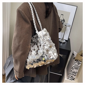 Primo piano della borsa tote con paillettes argento e tracolla intrecciata su modella