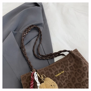 Detail of leopard print suede tote bag with Creative Cat text and bear charm accessory