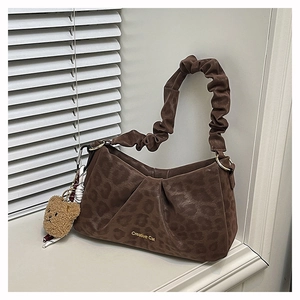 Detail of coffee leopard print bag with ruched handle and cute brown bear charm accessory