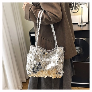 Dettaglio delle paillettes argentate e della piastra logo sulla borsa a spalla trendy