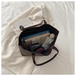Flat lay of large checkered tote bag showing spacious interior with tablet and books