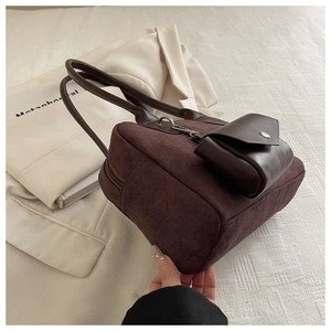 Detail of dark brown matte shoulder bag with long straps and mini matching pouch