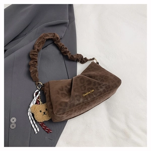 Detail of brown leopard print suede bag with gold Creative Cat logo and teddy bear charm