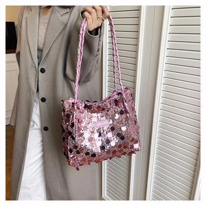 Detailed view of pink sequin shoulder bag featuring large reflective discs and woven straps