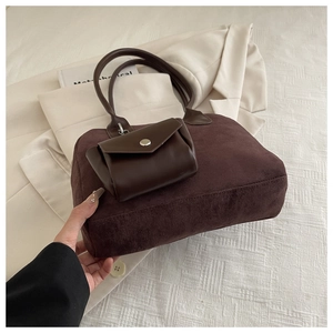 Detail of dark brown suede shoulder bag with extra small leather pouch for daily commute