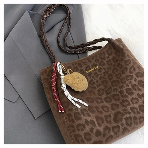Detail of leopard print tote bag with woven strap and creative cat gold text