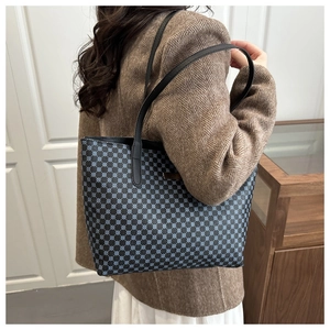 Detail view of large checkered tote bag showing blue circular patterns and black straps