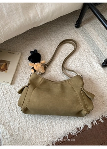 Detail of vintage dark green suede shoulder bag with a functional large side pocket