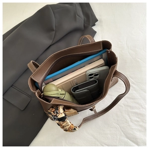 Interior view of brown tote bag showing large capacity with silk scarf on handle