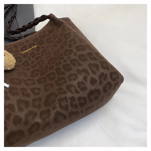 Close-up of leopard print tote bag with Creative Cat gold lettering and woven strap