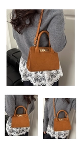 Détail d'un sac à main en daim marron caramel avec boucle dorée et poignées rondes