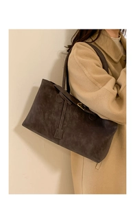 Close-up of matte coffee tote bag texture with elegant gold buckle and strap detail