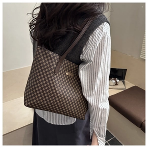 Detail view of the brown geometric pattern tote bag on model's shoulder in soft light