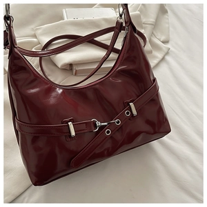 Détail du sac à bandoulière en cuir verni bordeaux avec boucle mors argentée chic