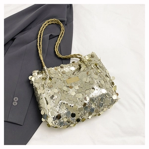 Close-up of champagne gold sequin bag featuring woven handles and a metallic logo plate