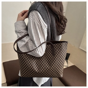 Detail view of large tote bag with dark coffee geometric pattern worn by a model