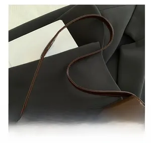 Close-up of comfortable brown glossy leather shoulder strap on a retro baguette bag
