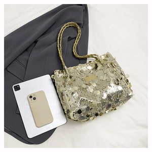 Detail of gold sequin tote bag with woven handles next to tablet and smartphone