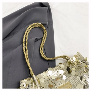 Detail of gold sequin shoulder bag with woven straps and a fashion logo label
