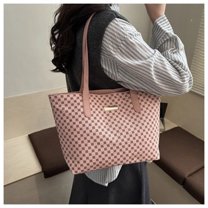 Pink tote bag with geometric circular patterns and gold plaque on a model's shoulder