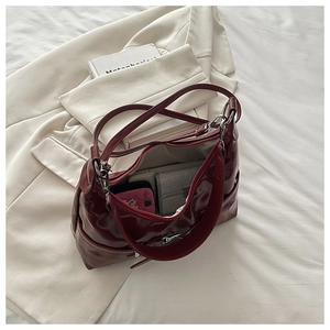 Vue de dessus d'un grand sac bandoulière bordeaux montrant un intérieur spacieux zippé