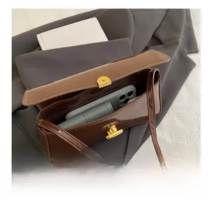Top view of brown patent leather baguette bag interior capacity with golden buckle