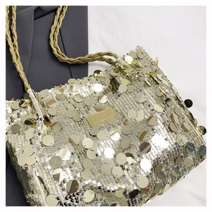Detail of champagne gold sequins on tote bag with woven rope handles and leather tag