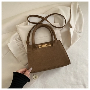 Dettaglio della borsa vintage marrone opaca con chiusura a rotazione in metallo dorato