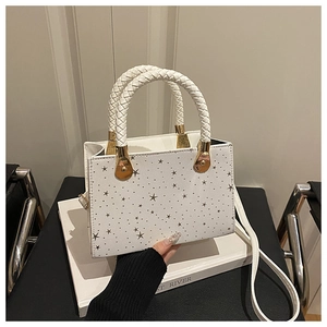 Chic white square crossbody bag featuring silver star patterns and woven handles