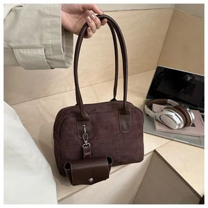 Detail of dark brown suede Boston bag with matching mini pouch on wooden steps
