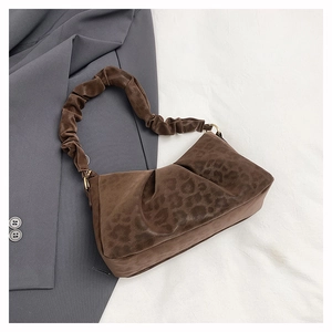 Detail of leopard print suede underarm bag featuring pleated handle and gold buckles