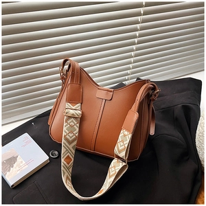 Detail of caramel brown faux leather bag with wide ethnic geometric woven strap