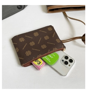 Top view of a printed brown zip pouch holding a smartphone and small daily items