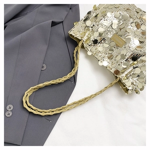 Detail of sequins and braided cord handle on a large gold fashion tote bag