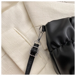 Detail of black pleated cloud bag showing silver lobster clasp and adjustable shoulder strap