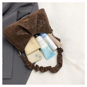Interior view of leopard print ruched shoulder bag showing storage for phone and makeup